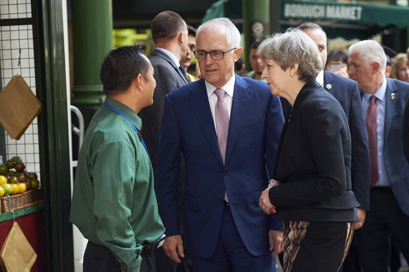 Theresa May and Malcolm Turnbull speak with a market trader during a visit to the scene of the London Bridge terror attack that left eight dead