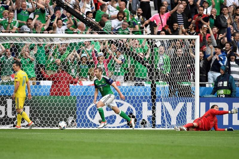 Northern Ireland midfielder Niall McGinn, centre, celebrates scoring against Ukraine goalkeeper Andriy Pyatov. Jeff Pachoud / AFP
