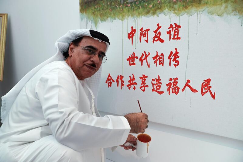 Abu Dhabi, U.A.E., July 17, 2018.   The Launch of China Week at Manarat Al Saadiyat with guests of honor, Noura Al Kaabi, Minister of Culture and Knowledge Development and Ni Jian, Ambassador of China.-- Emirati Artist, Mohammed Mandi infront of his collaborative painting with Chinese artist and teacher, Jack Lee of the Tiananmen Square entrance and the Qasr Al hosn Fort. 
Victor Besa / The National
Section:  NA
Reporter:  John Dennehy