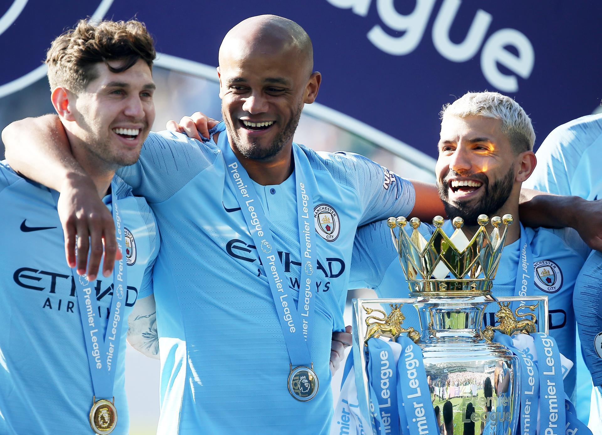 epa07565268 Manchester City captain Vincent Kompany (C) celebrates with teammates John Stones (L) and Sergio Aguero after the English Premier League match between Brighton and Hove Albion and Manchester City, Brighton, Britain, 12 May 2019. Manchester City won 4-1 and won the Premier League title. EPA/JAMES BOARDMAN EDITORIAL USE ONLY. No use with unauthorized audio, video, data, fixture lists, club/league logos or 'live' services. Online in-match use limited to 120 images, no video emulation. No use in betting, games or single club/league/player publications.