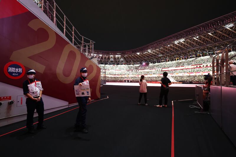 Members of staff hold signage inside the stadium before the opening ceremony.
