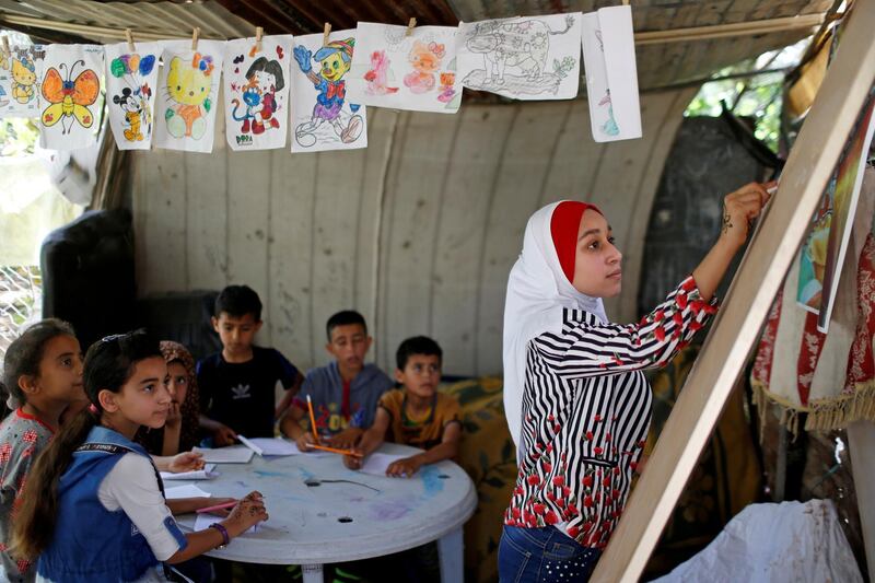 A Palestinian school girl Fajr Hmaid, 13, teaches her neighbours' children an Arabic language lesson as schools are shut due to the coronavirus disease (COVID-19) restrictions, at her family house in Gaza, May 19, 2020. REUTERS/Mohammed Salem     TPX IMAGES OF THE DAY