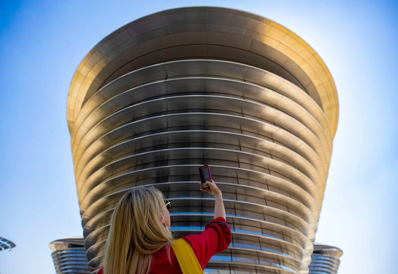 A woman takes a picture of the Mobility Pavilion on the 11th day of Expo 2020 Dubai. Chris Whiteoak / The National