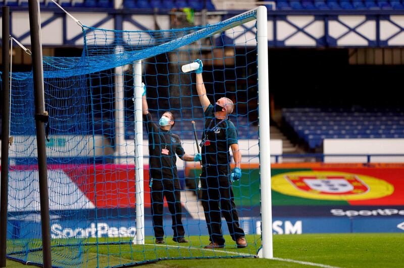 Staff disinfect the goalposts at half time at Goodison Park. AFP