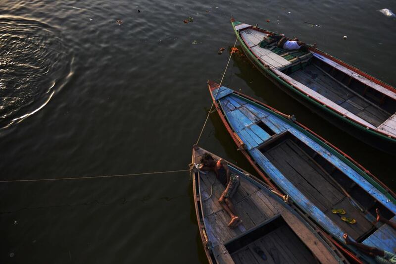 Indian men sleep on wooden boats tied together and moored to one of the ghats on the Ganges river in Varanasi. The Ganges river is considered sacred in the Hindu religion and is revered as a goddess. Roberto Schmidt / AFP 