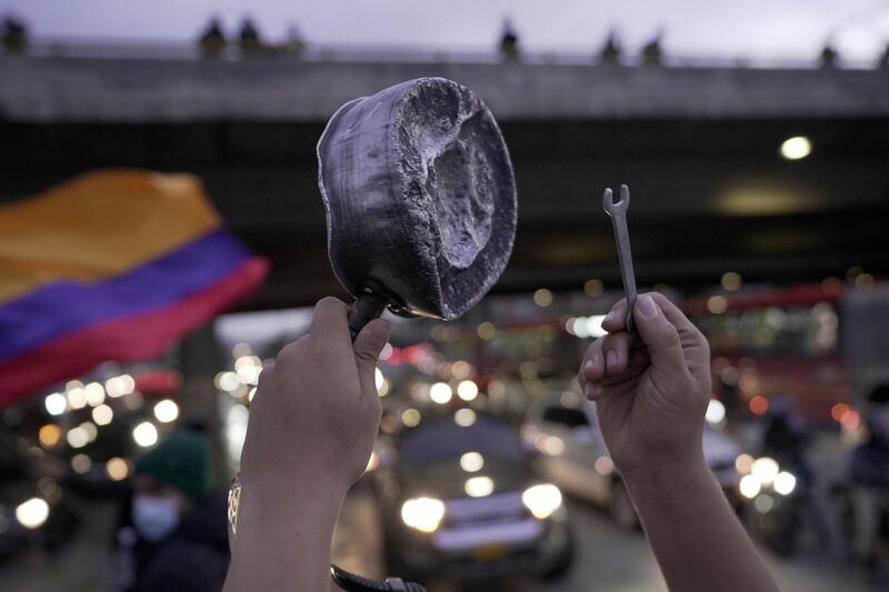 BOGOTA, COLOMBIA - MAY 04: A demonstrator bangs a pot among traffic on the north highway of the city during the sixth day of the national strike on May 04, 2021 in Bogota, Colombia. Violent clashes between protestors and riot police continue after President Duque ordered Congress the withdrawal of his tax reform bill on Sunday. Demonstrations turned into a national outcry against rising poverty, inequality and unemployment. At least 19 people were reported dead and over 800 injured. (Photo by Diego Cuevas/Vizzor Image/Getty Images)