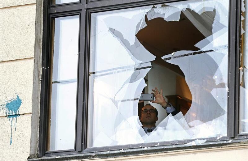 A man takes pictures of a broken window at the Turkish embassy in Moscow during a protest by Russians on November 25, 2015. Maxim Shipenkov/EPA