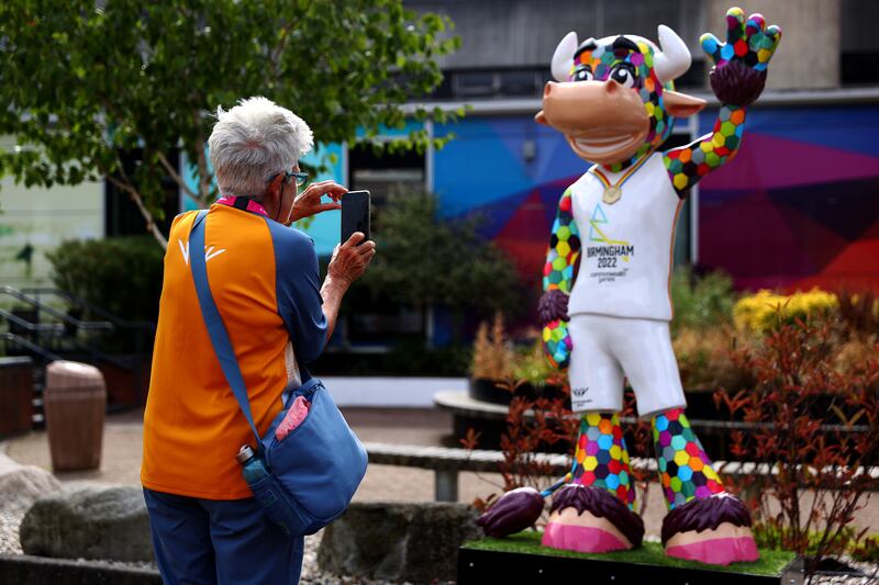 A volunteer takes a photo of the Perry the Bull, the official mascot of the Commonwealth Games, at the NEC. Getty Images