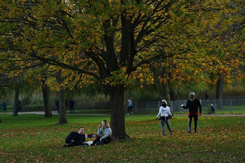 A couple enjoy a picnic as a fencing lesson takes place on Clapham Common in London. Reuters