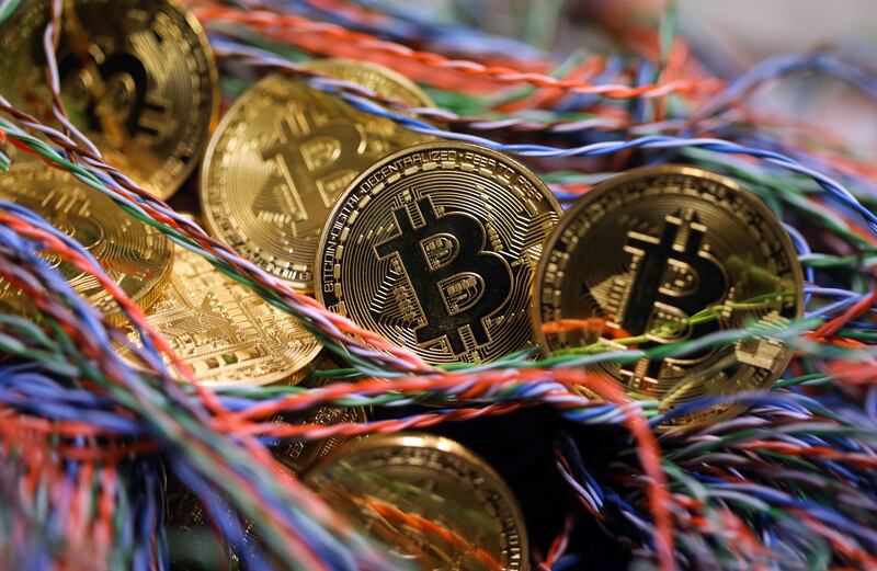 Bitcoins sit among twisted copper wiring inside a communications room at an office in this arranged photograph in London, U.K., on Tuesday, Sept. 5, 2017. Bitcoin steadied after its biggest drop since June as investors and speculators reappraised the outlook for initial coin offerings. Photographer: Chris Ratcliffe/Bloomberg