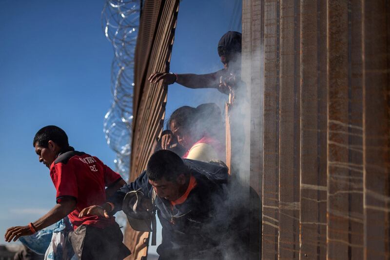 Migrants, part of a caravan of thousands from Central America trying to reach the United States, return to Mexico after being hit by tear gas by U.S. Customs and Border Protection (CBP) after attempting to illegally cross the border wall into the United States in Tijuana, Mexico November 25, 2018. REUTERS/Adrees Latif     TPX IMAGES OF THE DAY