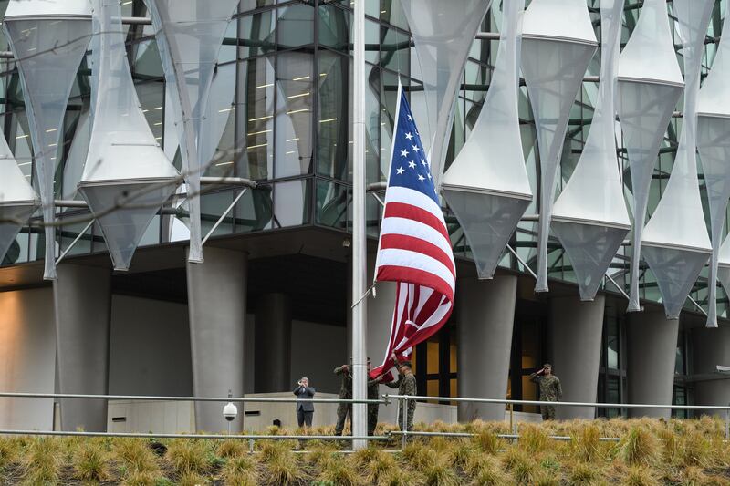 A soldier salutes as the American flag is raised at the Nine Elms embassy building for the first time in January 2018. Getty Images