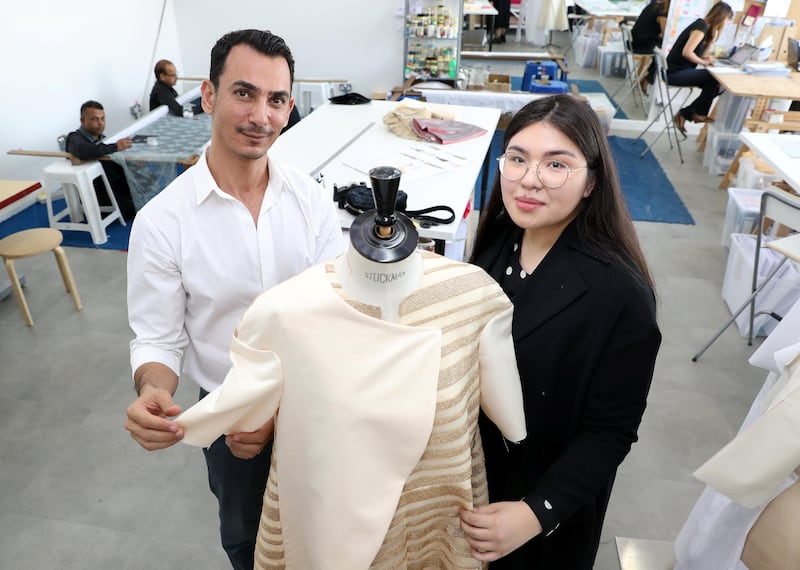Dubai, United Arab Emirates - August 23rd, 2017: A feature on fashion designer Rami Al Ali (L) & Karashash Nurakhmet a ESMOD fashion school intern. Karashash is designing clothes which will then be sold, and Rami Al Ali is helping lend his industry knowledge. Wednesday, August 23rd, 2017 at The Design District, Dubai. Chris Whiteoak / The National