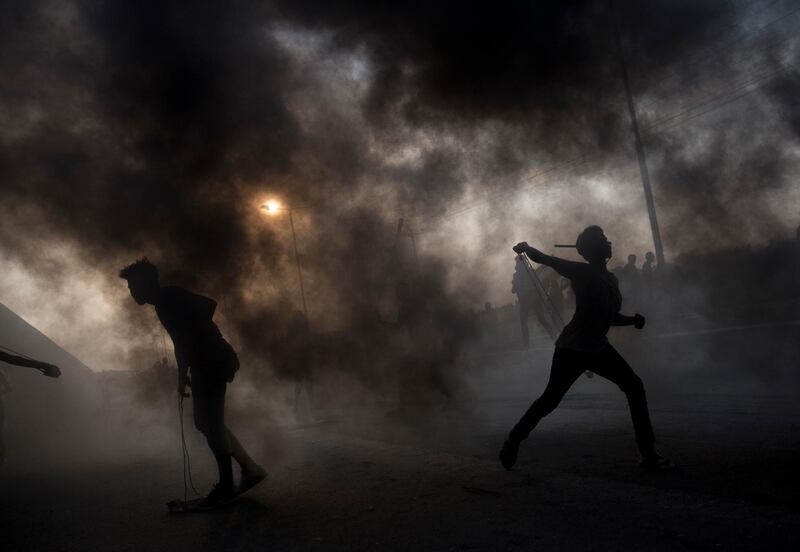 Palestinian protesters hurl stones during a demonstration at the entrance of Erez border crossing between Gaza and Israel, in the northern Gaza Strip. AP Photo