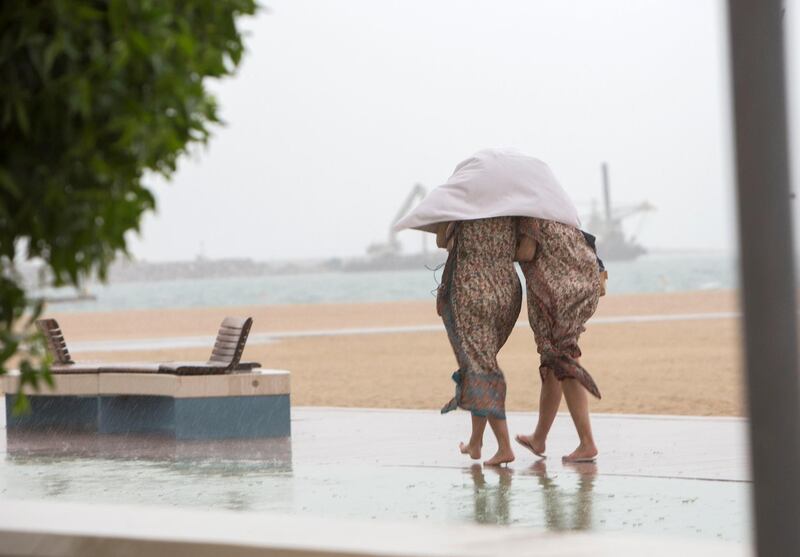 Dubai, United Arab Emirates -Beach goers taking cover from rain  at Kite beach, Dubai.  Leslie Pableo