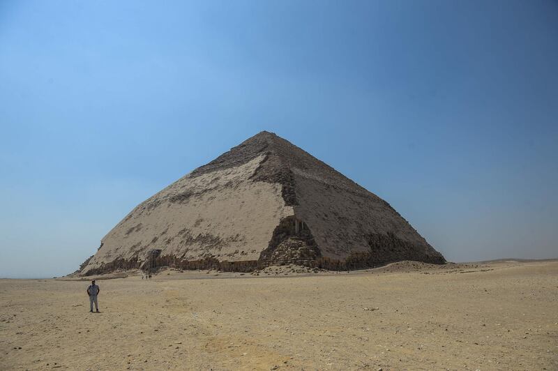 A picture taken on July 13, 2019 shows the Bent pyramid of King Sneferu, the first pharaoh of Egypt's 4th dynasty, in the ancient royal necropolis of Dahshur on the west bank of the Nile River, south of the capital Cairo. An Egyptian archaeological mission discovered a collection of stone, clay and wooden sarcophagi, of which some are still containing well preserved mummies, as well as a collection of wooden funerary masks and instruments used in cutting stones .  / AFP / Mohamed el-Shahed
