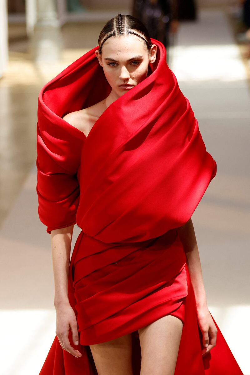 A model is wrapped in dramatic red. Reuters