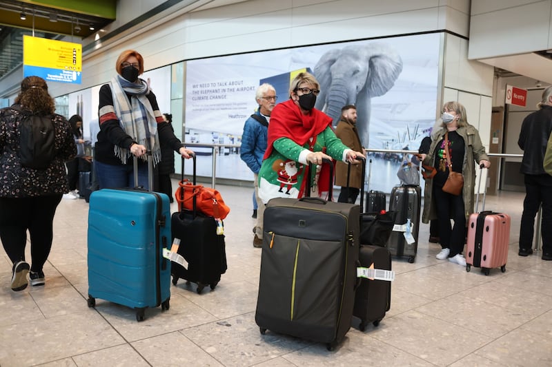Airline passengers wear face masks in the arrivals hall at Heathrow Airport in London, on December 23.  Bloomberg.