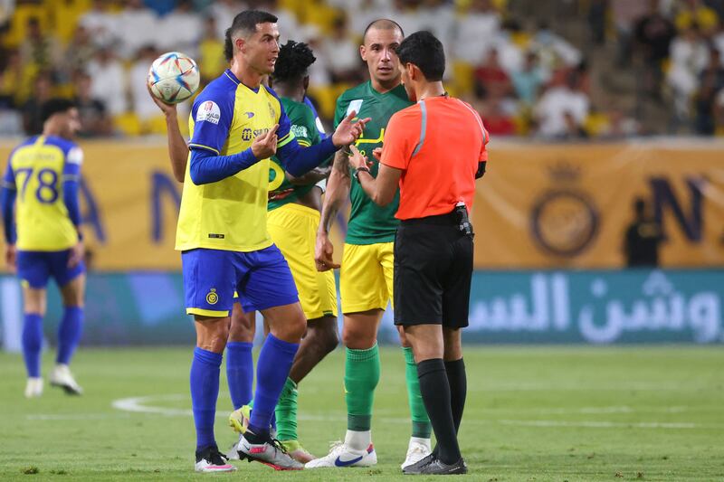 Cristiano Ronaldo talks to Saudi referee Majed Al-Shamrani during the Saudi Pro League football match between Al Nassr and Al Khaleej.