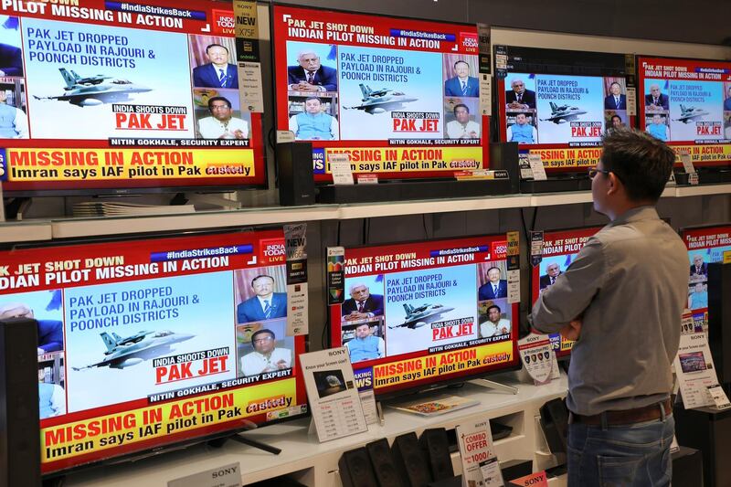 A man watches a television reports on the confrontation between Indian and Pakistani fighter jets in an electronics store in New Delhi, India. Bloomberg