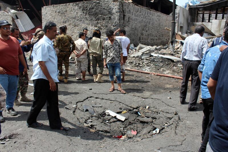 A picture taken on March 13, 2018 in the southern Yemeni city and government bastion of Aden shows Yemenis inspecting the site of an explosion from a suicide bombing claimed by the Islamic State (IS) group which hit UAE-trained Yemeni troops.
The attack in the north of the port city hit an army mess hall serving the so-called Security Belt brigade, which is supported by government ally the UAE, according to a security source. / AFP PHOTO / SALEH AL-OBEIDI