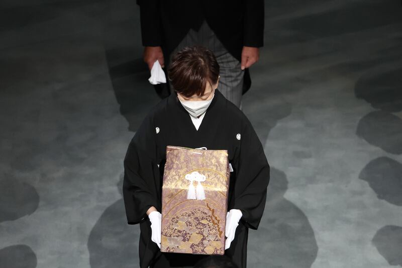 Abe's widow Akie carries her husband's ashes during the funeral. Protests opposing it have taken place across Japan for the longest-serving leader in its modern history and one of the most divisive. Getty Images