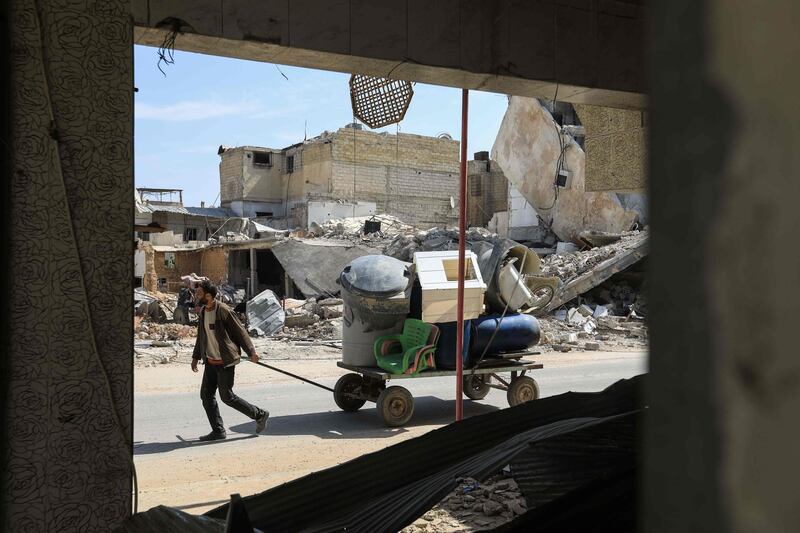 A Syrian man pulls a wagon filled with belongings as he flees the shelling. Abdullah Hammam / AFP Photo