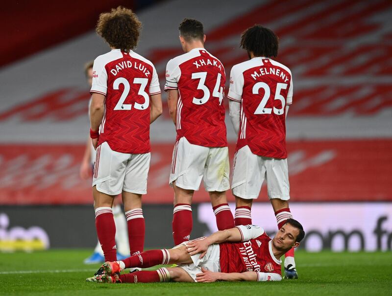 Arsenal's Cedric Soares lies down behind a wall before a Tottenham Hotspur free kick. Reuters