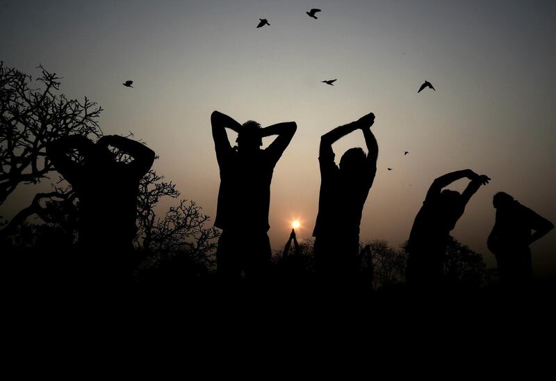 A group of Yoga enthusiasts are silhouetted against the sky as they perform Surya Namaskar or 'sun salutation' on the occasion of 'Ratha Saptami' Hindu festival, which is dedicated to Lord Surya, in Bangalore, India. Jagadeesh NV / EPA