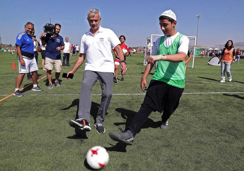 Portuguese football coach Jose Mourinho plays with a Lebanese Druze boy during the launching ceremony of FIFA's programme "Football for Schools" in the town of Kahlouniye, in the Chouf region, south of the Lebanese capital Beirut. AFP