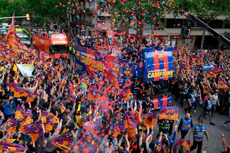 Thousands of fans line the streets as the Barcelona players parade their trophies. Enric Fontcuberta / EPA
