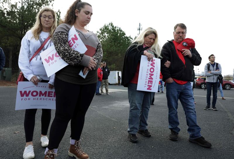 Supporters of Mr Walker say a prayer during a campaign rally in Loganville. Getty Images / AFP