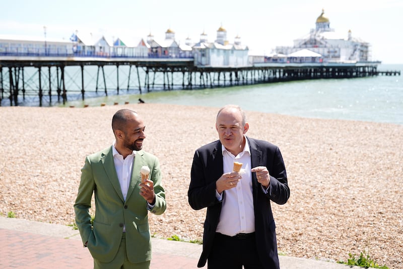 Mr Davey, right, eats ice cream with his party's local candidate, Josh Babarinde, on the promenade in Eastbourne. PA