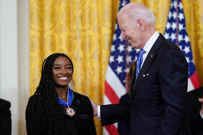 Mr Biden awards Simone Biles, the most decorated US gymnast in history. AP