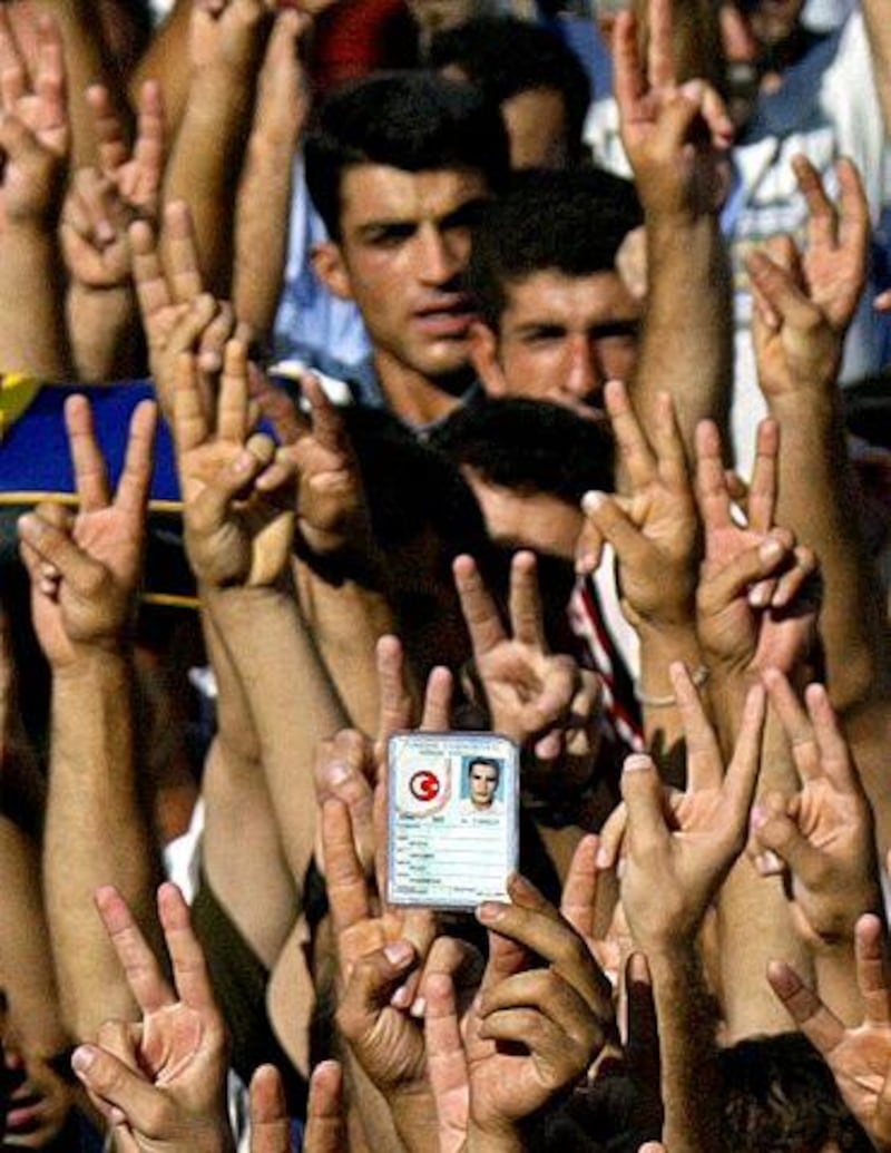 Kurdish demonstrators hold their Turkish identity cards as they demand that they be changed to Kurdish ones.