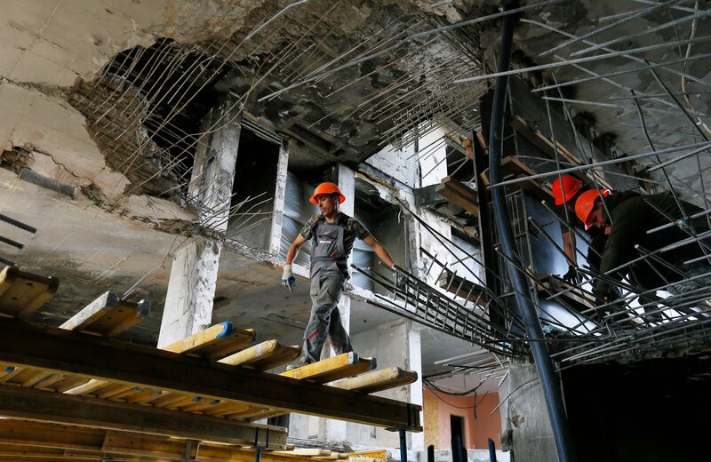 Ukrainian workers repair a flat damaged by shelling in the southern city of Odesa. EPA