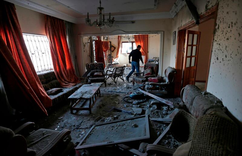 A Palestinians man walks among debris and scatterred objects.  AFP