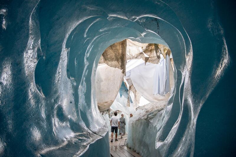 People visit the Ice cave in the Rhone Glacier above Gletsch near the Furkapass in Switzerland. The oldest Alps glacier  is protected by special white blankets to prevent it from melting. AP