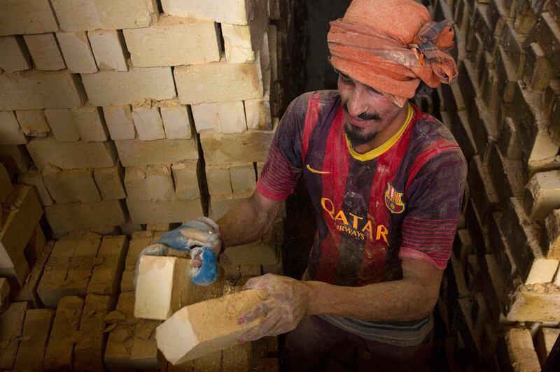 A worker stacks bricks at the factory. AFP