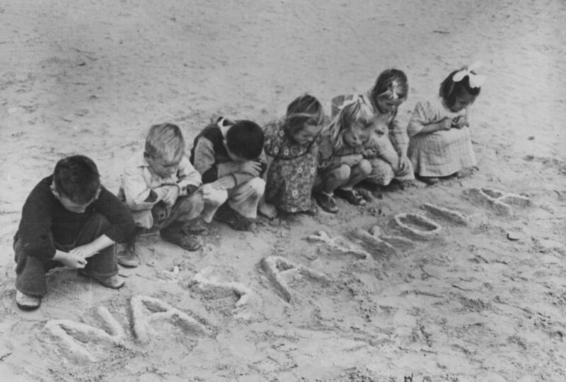 An image of refugee children at the Tolumbat camp in Egypt using the sands as their blackboards and notebooks, and fingers as pencils because of a lack of school supplies, is an echo of what child refugees struggled with then, and today.   United Nations Relief and Rehabilitation Administration