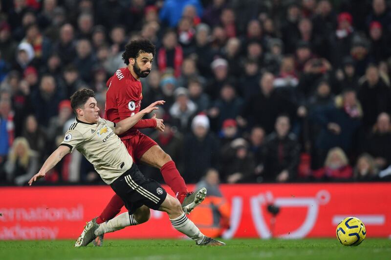 Liverpool's Egyptian midfielder Mohamed Salah (R) shoots to score their second goal as Manchester United's Welsh midfielder Daniel James (L) slides to attempt a block during the English Premier League football match between Liverpool and Manchester United at Anfield stadium in Liverpool, north west England on January 19, 2020. (Photo by Paul ELLIS / AFP) / RESTRICTED TO EDITORIAL USE. No use with unauthorized audio, video, data, fixture lists, club/league logos or 'live' services. Online in-match use limited to 120 images. An additional 40 images may be used in extra time. No video emulation. Social media in-match use limited to 120 images. An additional 40 images may be used in extra time. No use in betting publications, games or single club/league/player publications. / 