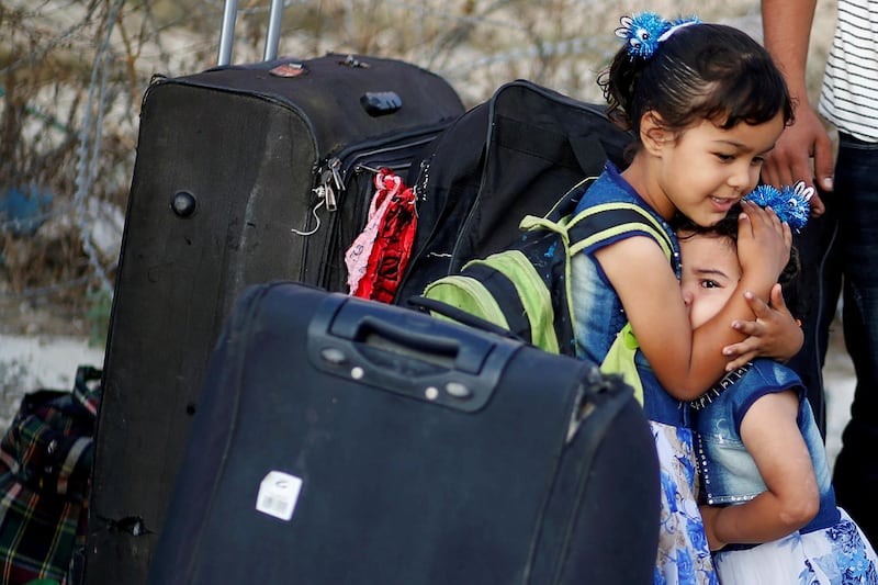 A girl hugs her sister as she cries before they leave the Palestinian Rafah border crossing with Egypt. Reuters