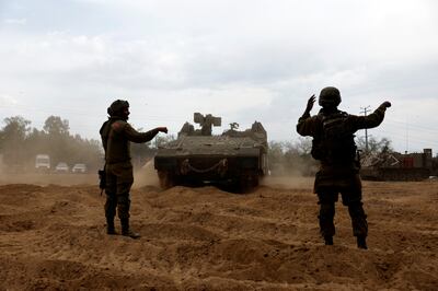 Israeli soldiers direct an Armoured Personnel Carrier mid a military build-up along the border with Gaza. Reuters.