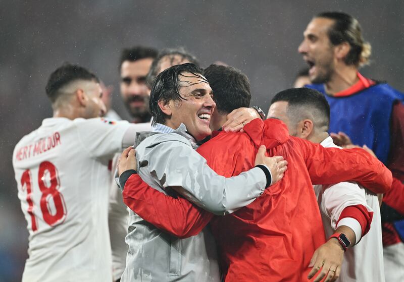 Turkey manager Vincenzo Montella celebrates with coaching staff and players after defeating Austria. Getty Images