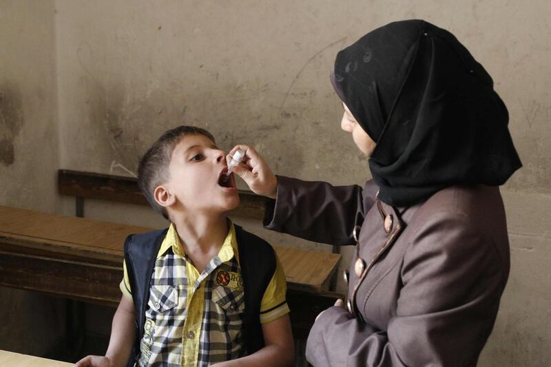 A health worker administers a polio vaccination to a child in Aleppo, Syria, on May 4, 2014. Hosam Katan / Reuters