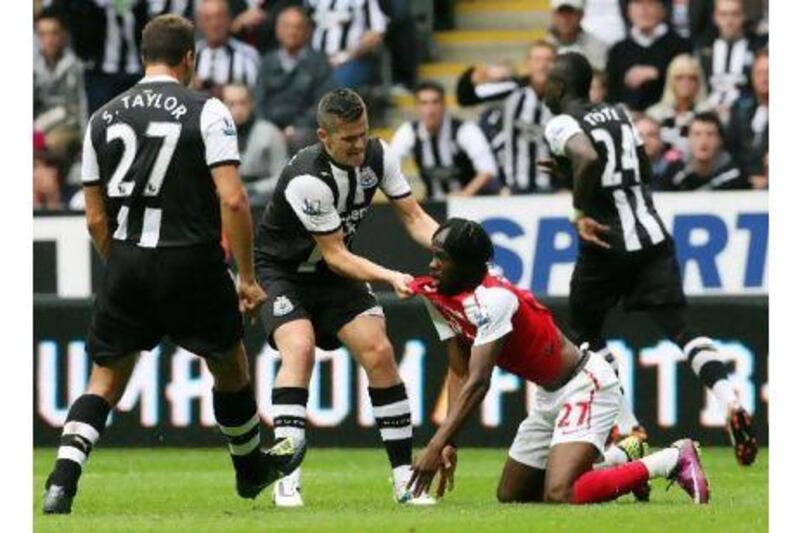 Newcastle's Joey Barton hauls Arsenal's Gervinho to his feet at the start of the scuffle.
