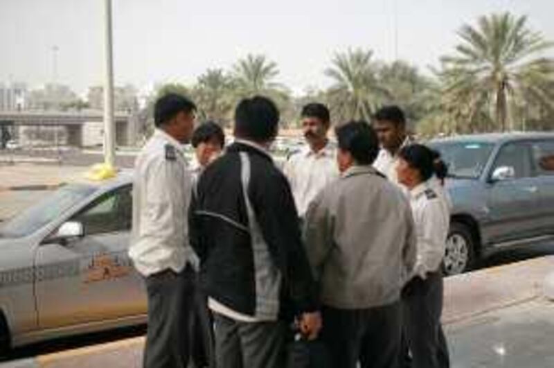 Abu Dhabi - February 16, 2009: Taxi drivers from Tawasul talk with each other during a strike near the Trans AD building at 4th and Delma st. ( Philip Cheung / The National ) *** Local Caption ***  PC0001-TaxiStrike.jpg