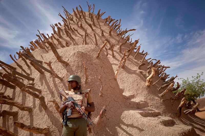 TOPSHOT - A soldier of the Malian army patrols the archaeological site of the Tomb of Askia in Gao on March 10, 2020.  The site, which was protected during the 10 months of jihadist occupation in 2012, represents one of the finest examples of Sudano-Sahelian architecture in the Sahel region. / AFP / MICHELE CATTANI
