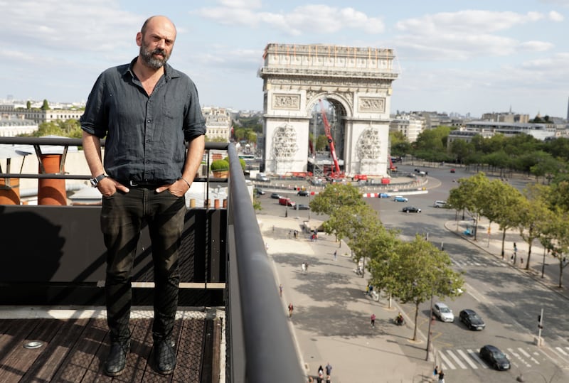 Vladimir Yavachev, a nephew of late artist Christo, who leads the "L'Arc de Triomphe, Wrapped" project poses near at the Arc de Triomphe in Paris, Tuesday, Aug. 24, 2021.  The "L'Arc de Triomphe, Wrapped" project by late artist Christo and Jeanne-Claude will be on view for 16 days from, Sept. 18 to Oct.  3, 2021.  The famed Paris monument will be wrapped in 25,000 square meters of fabric in silvery blue, and with 3,000 meters of red rope.  (AP Photo / Adrienne Surprenant)