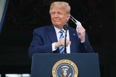 US President Donald Trump takes his mask off before speaking from the South Portico of the White House in Washington on Saturday. AFP